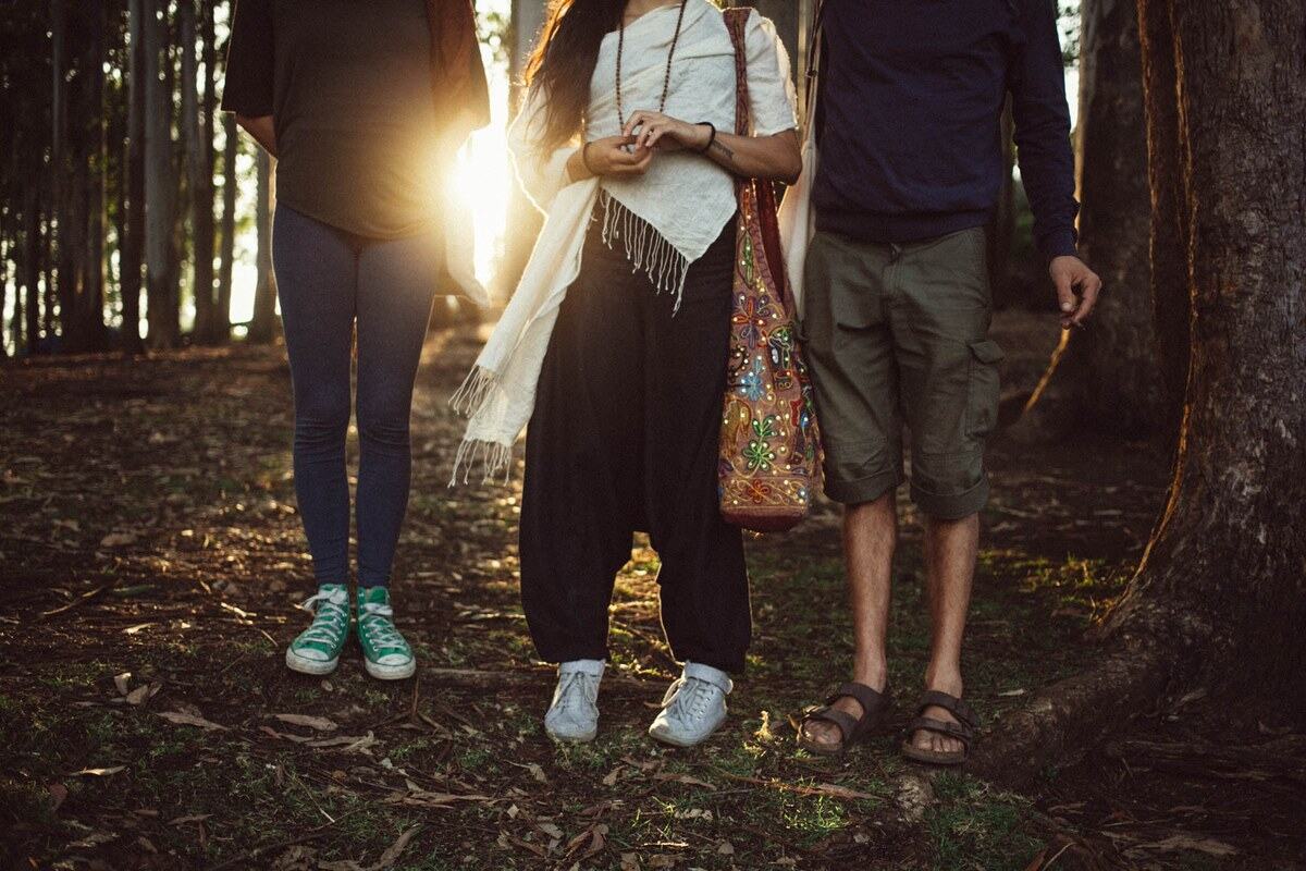 Three friends pause in Munnar forest light near Top Station, Kerala.