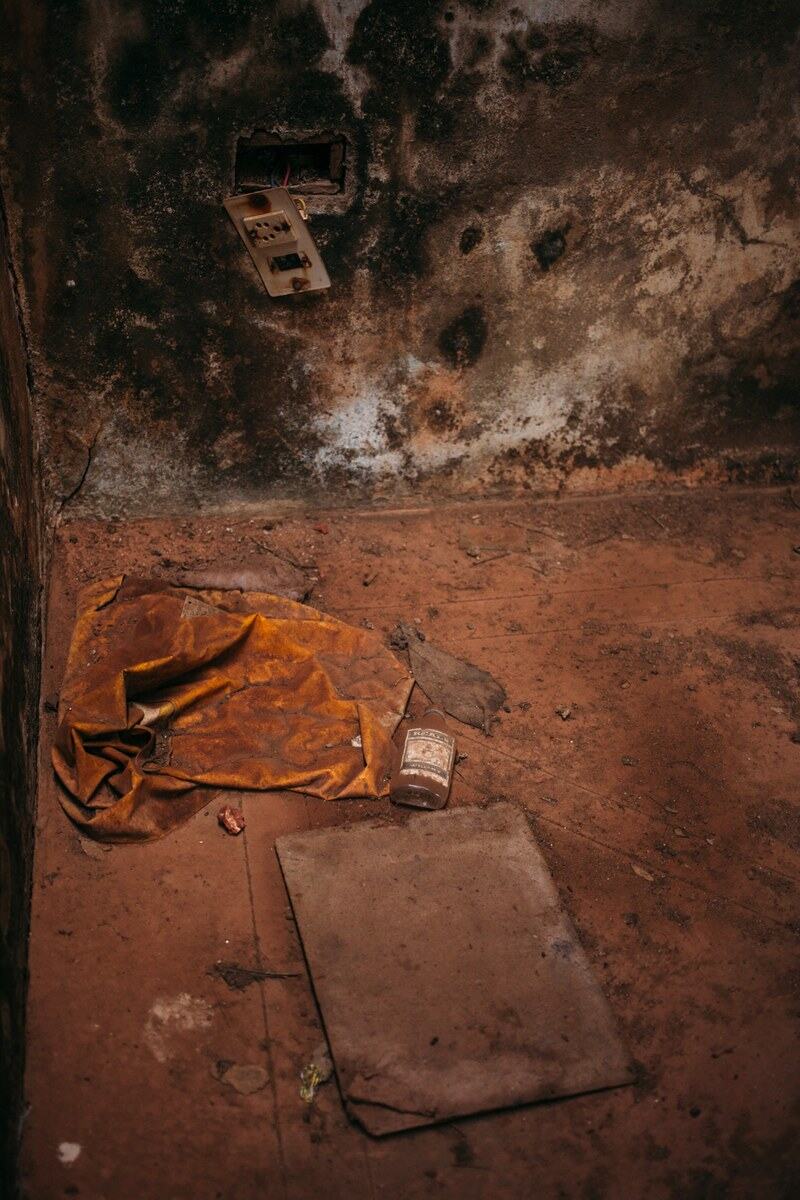 Warm roof light and worn plaster fill an abandoned room in Goa.