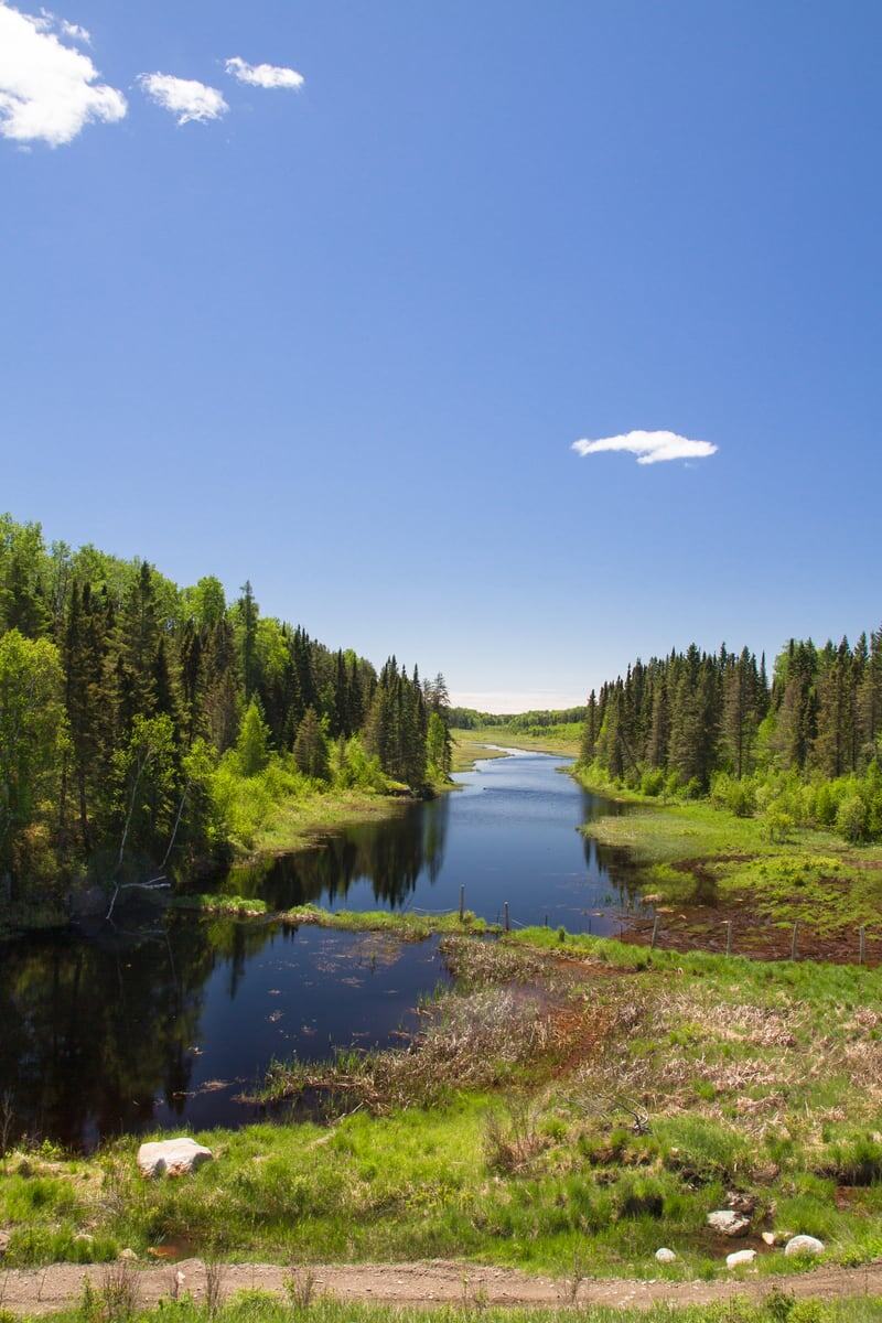 A narrow green water channel cuts through forested Northern Ontario near Sault Ste. Marie.
