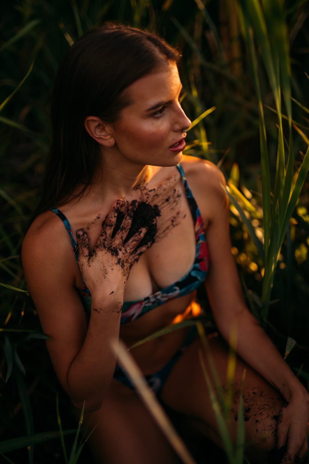 Mo in the Reeds story frame 4: Green shadow, tall grass, body paint and a charged quiet that stays grounded in portrait atmosphere.