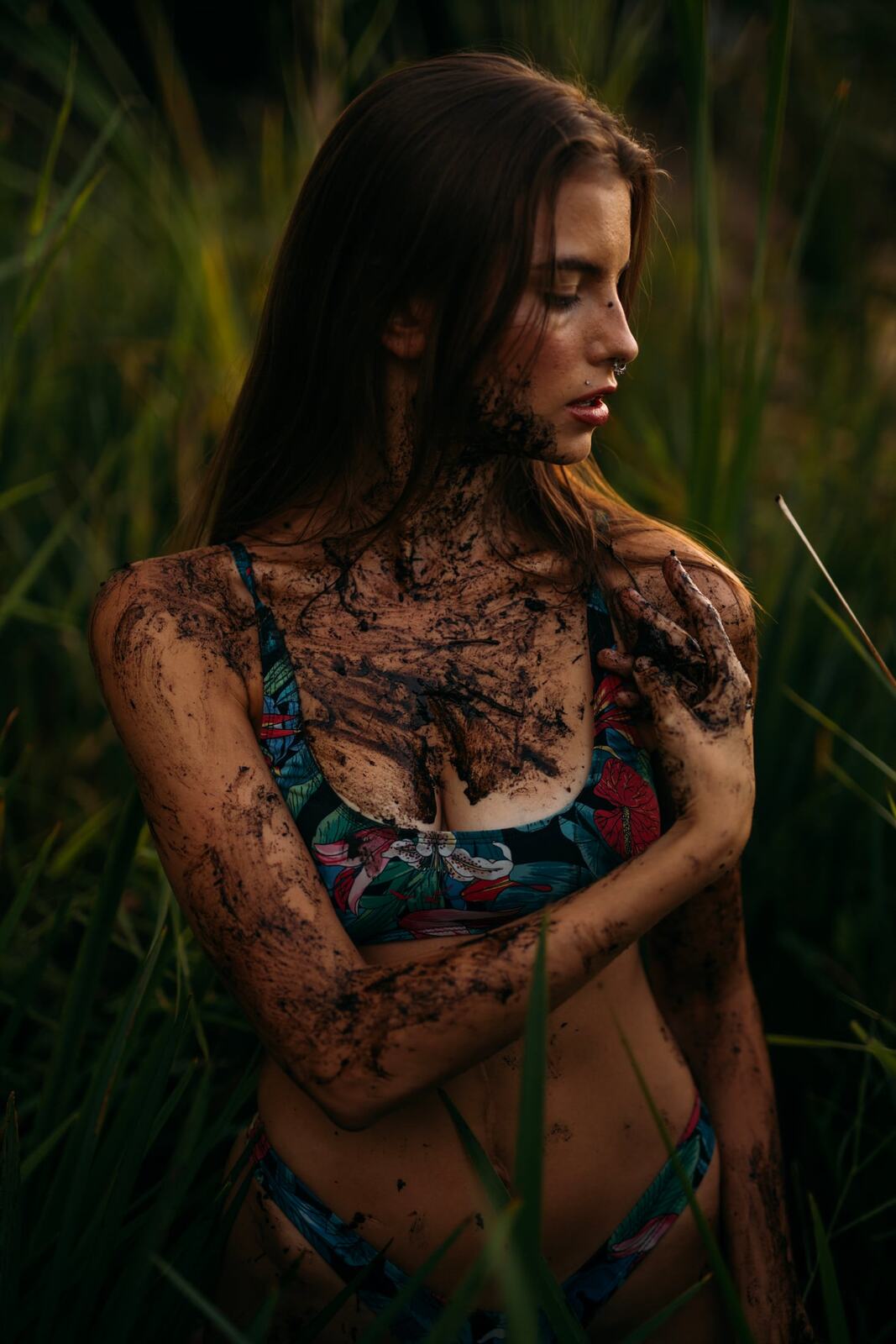 Mo in the Reeds story frame 7: Green shadow, tall grass, body paint and a charged quiet that stays grounded in portrait atmosphere.