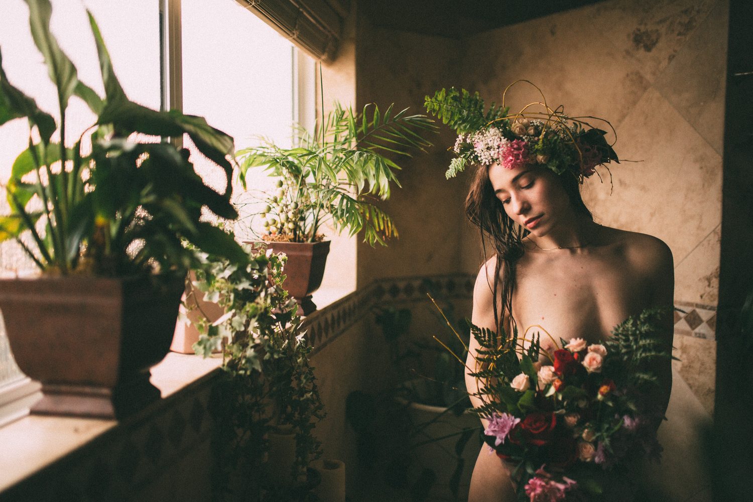 Bailey framed by window light and full florals beside the bath