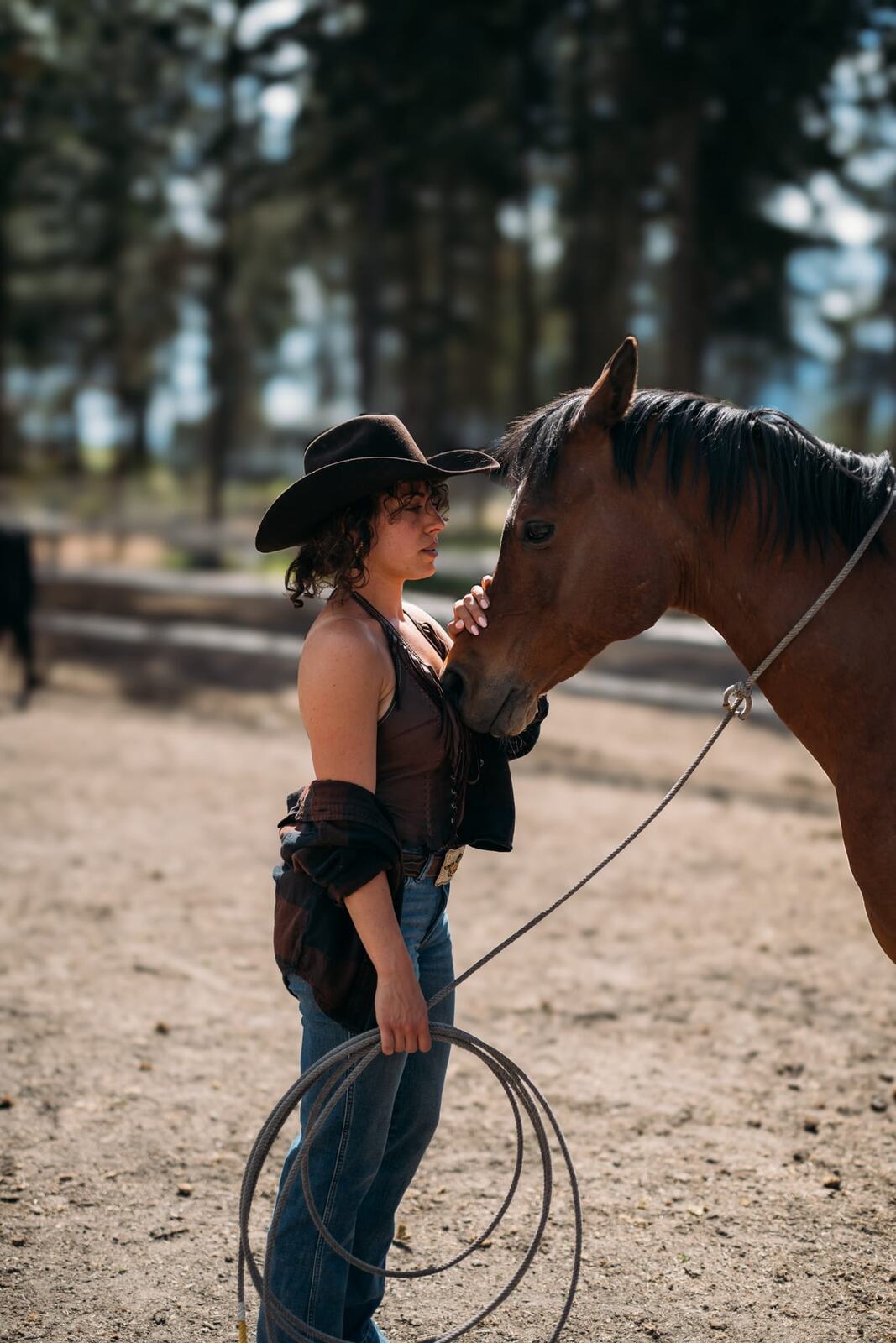 Giuliana at LoveReins portraits story frame 10: Equestrian portrait session at Love Reins Ranch in Lake Country, BC, with Giuliana, horses, white-dress portraits, Western cowgirl styling, ranch fencing, riding frames and warm Okanagan light..