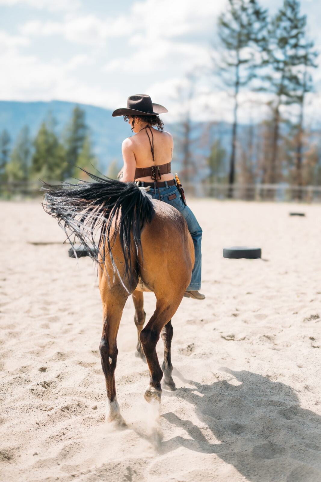 Giuliana at LoveReins portraits story frame 17: Equestrian portrait session at Love Reins Ranch in Lake Country, BC, with Giuliana, horses, white-dress portraits, Western cowgirl styling, ranch fencing, riding frames and warm Okanagan light..