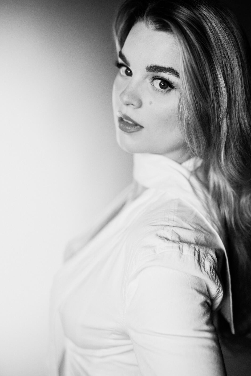 Hannah K in Black and White portraits story frame 14: A black-and-white studio portrait study with clean wardrobe shifts, close face work and controlled light.