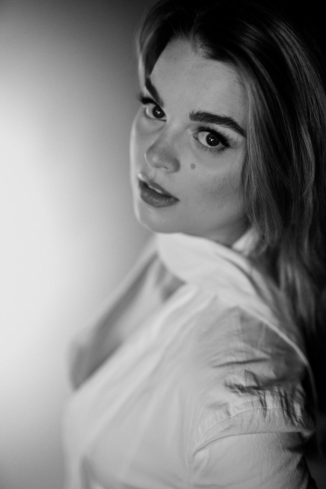 Hannah K in Black and White portraits story frame 15: A black-and-white studio portrait study with clean wardrobe shifts, close face work and controlled light.