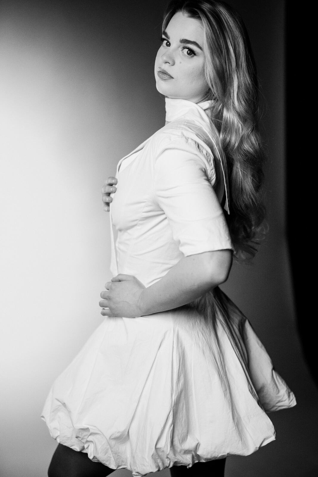 Hannah K in Black and White portraits story frame 12: A black-and-white studio portrait study with clean wardrobe shifts, close face work and controlled light.