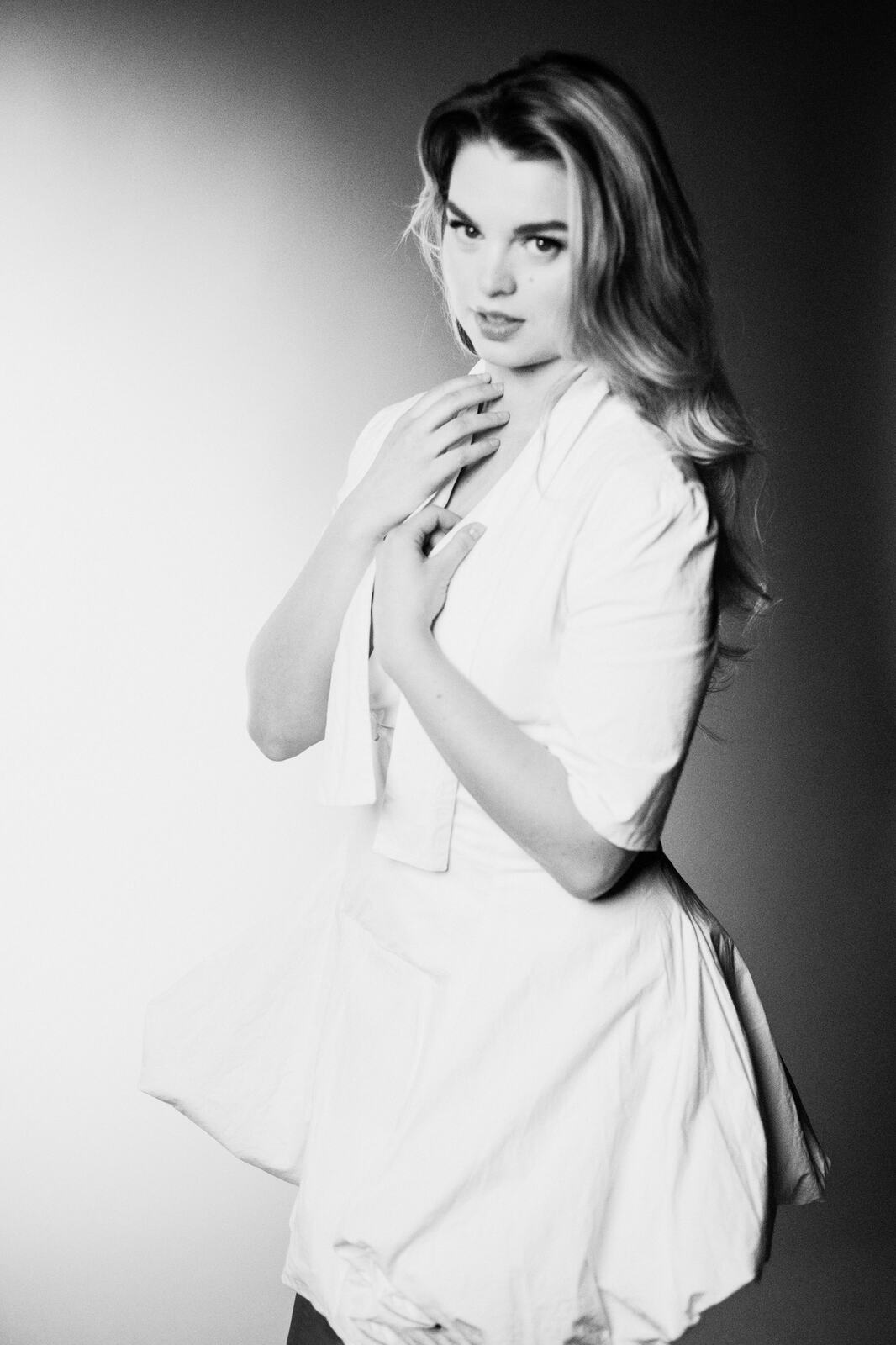 Hannah K in Black and White portraits story frame 19: A black-and-white studio portrait study with clean wardrobe shifts, close face work and controlled light.