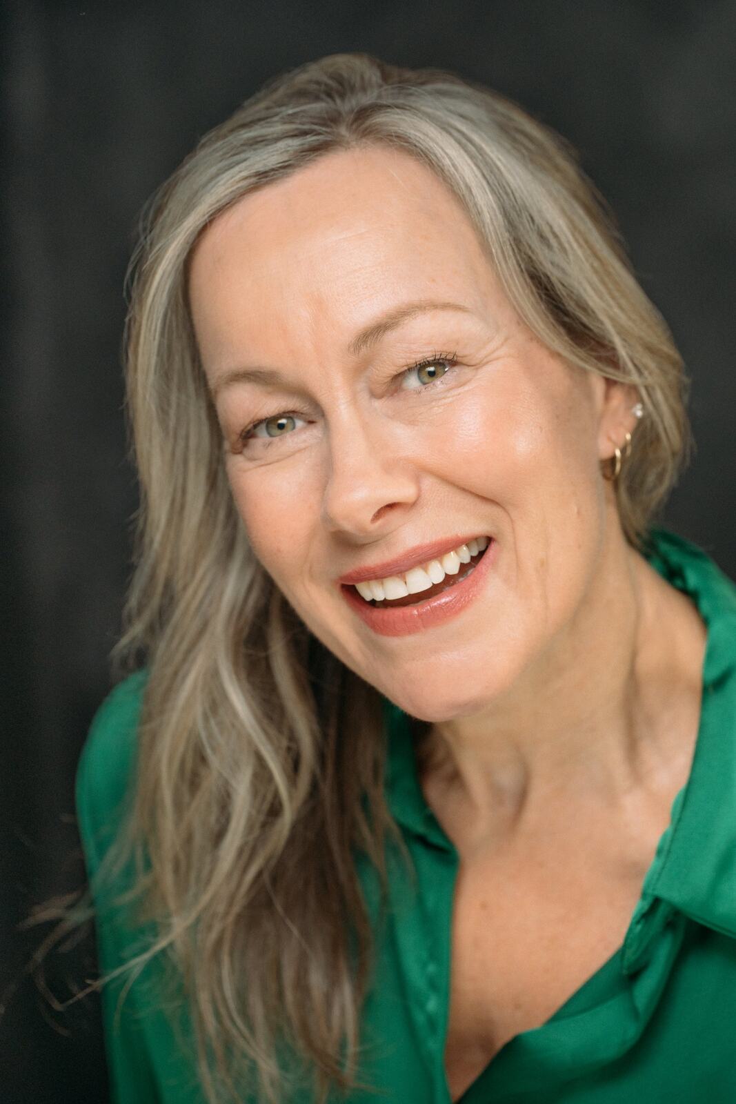 Shaye laughing in a bright green blouse
