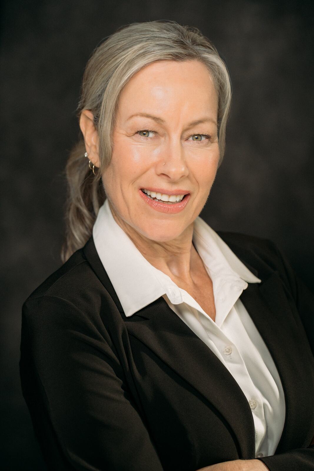 Shaye smiling in a black blazer