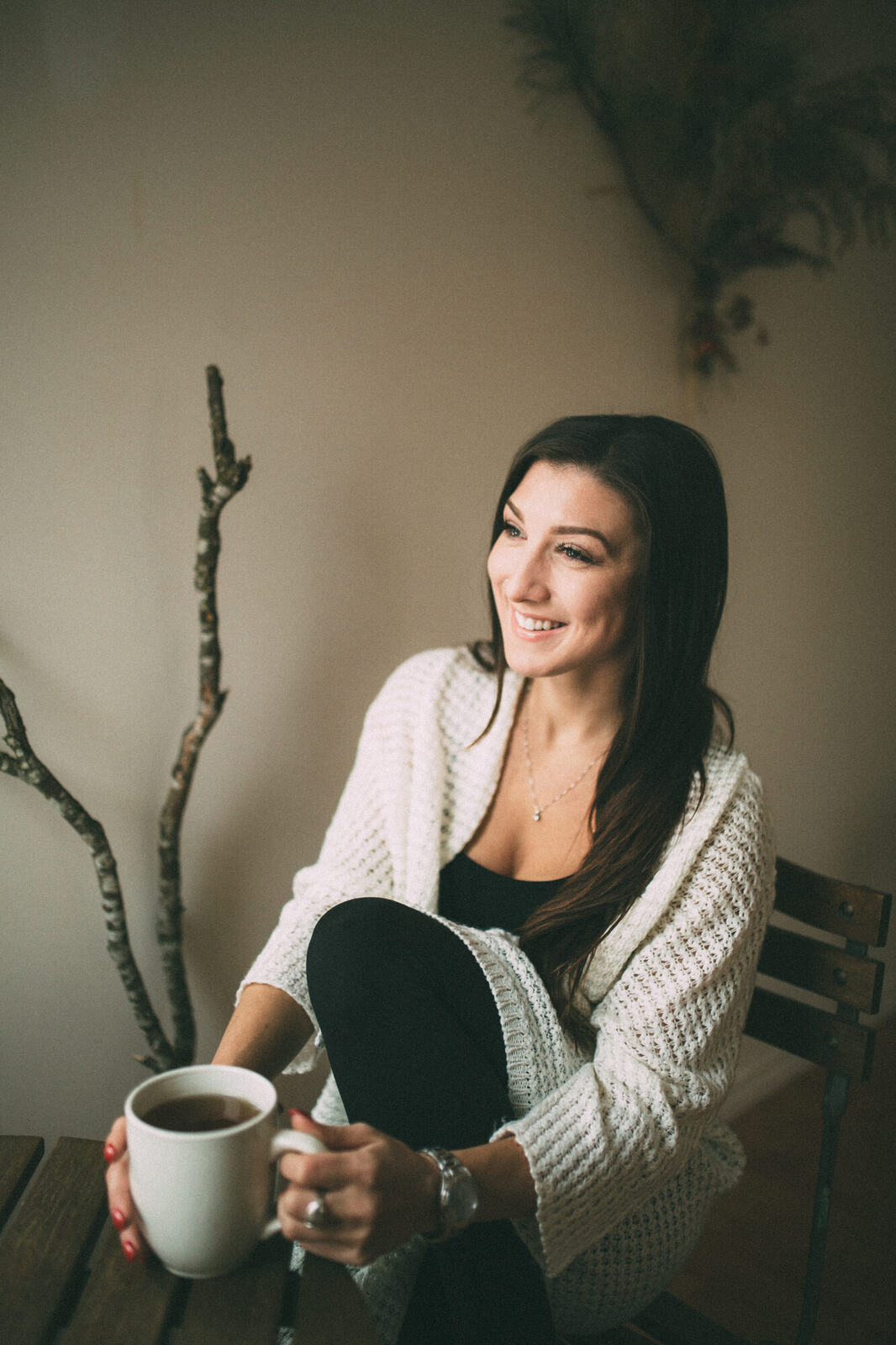 Jasmin by the Window portrait story frame 2: Window-light portraits with Jasmin beside a small table, tea and winter greenery in Kelowna, British Columbia.