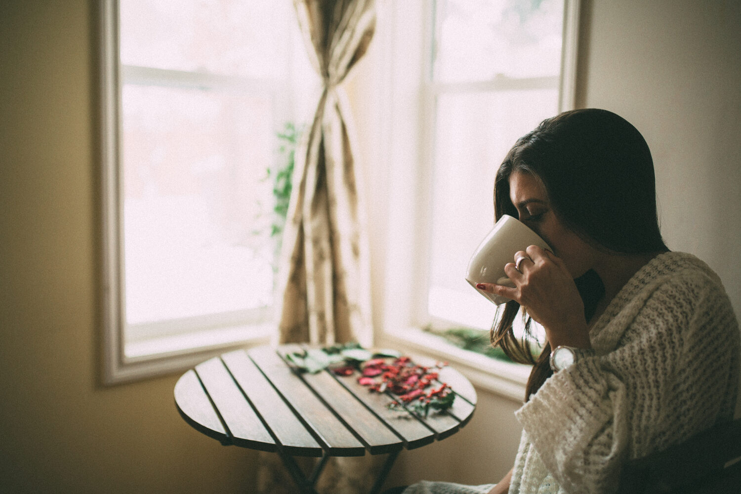 Jasmin by the Window portrait story frame 12: Window-light portraits with Jasmin beside a small table, tea and winter greenery in Kelowna, British Columbia.