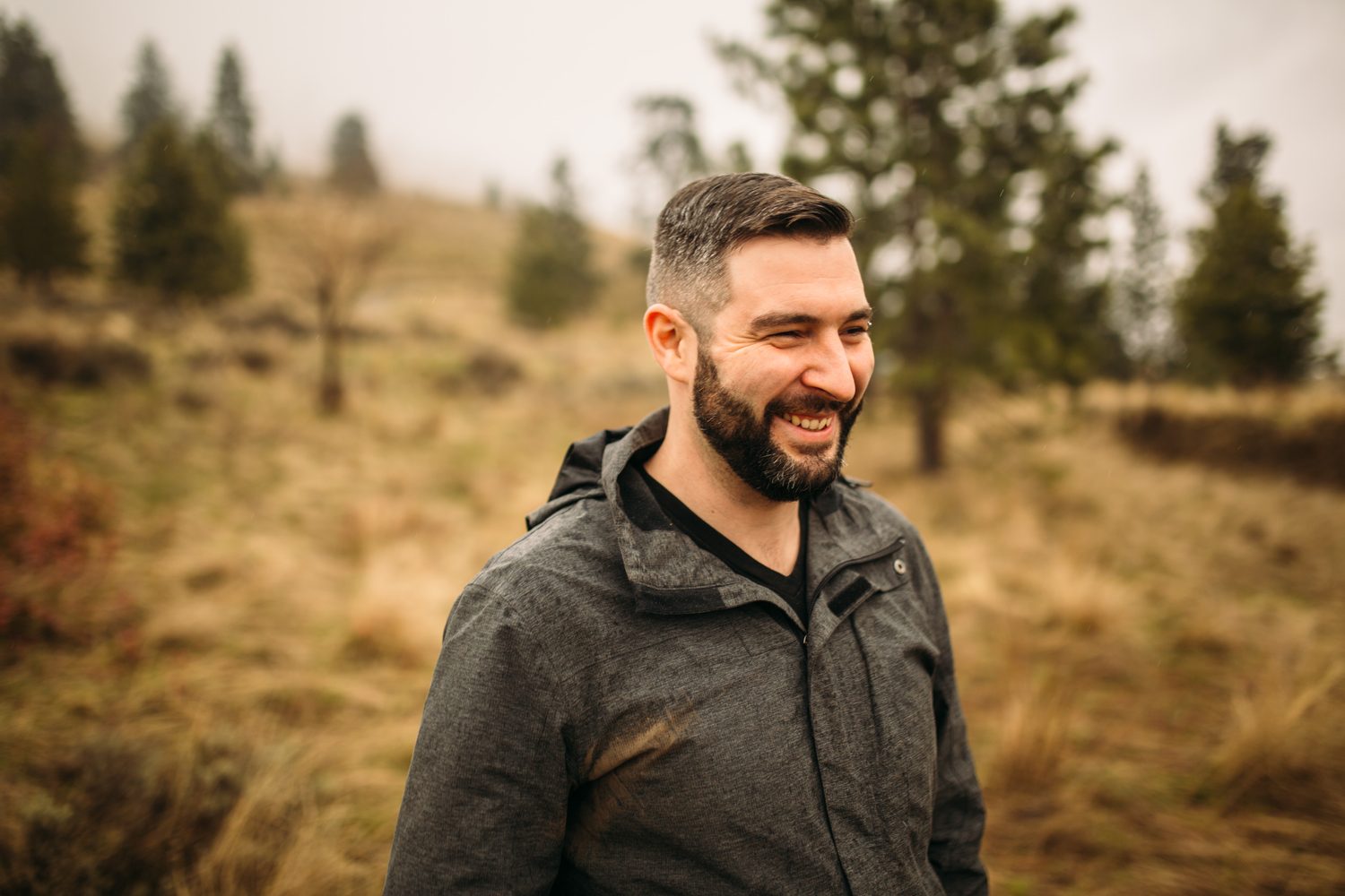 Jeremy standing in warm hillside light in a dark blazer for Optimize Organics.