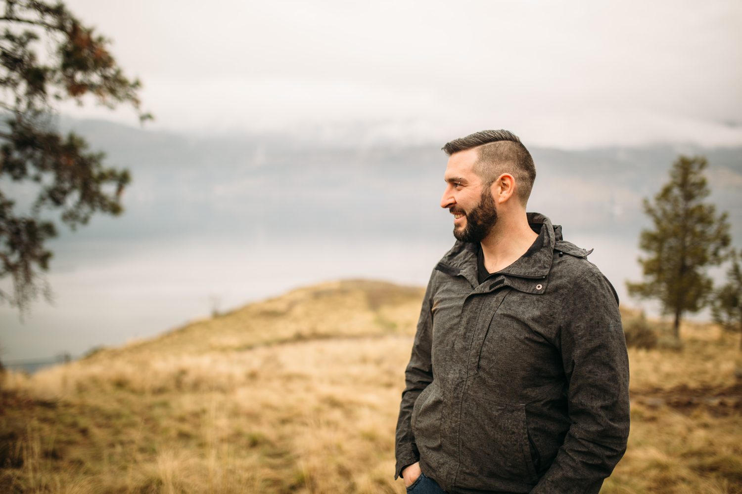 Jeremy standing in warm hillside light in a dark blazer for Optimize Organics.