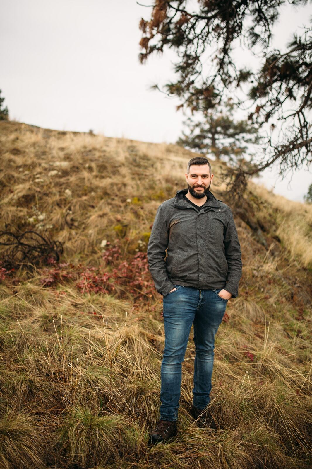 Jeremy standing in warm hillside light in a dark blazer for Optimize Organics.