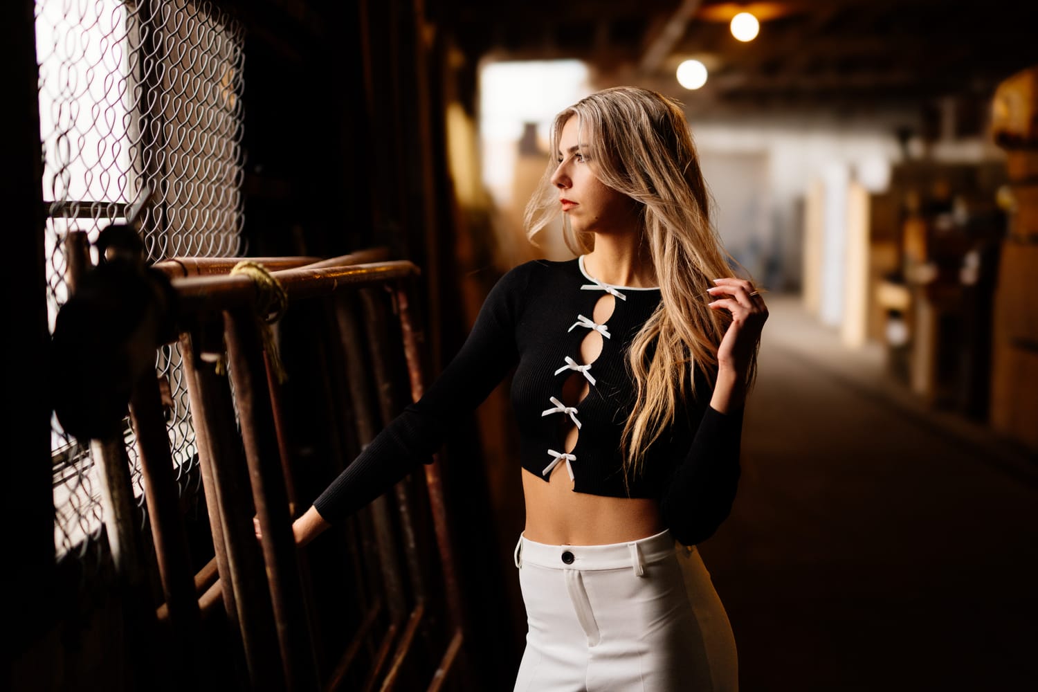 Kaylee in Clouds portraits story frame 15: Penticton portraits for Kaylee with cloud styling, warm industrial light, black lace-up wardrobe, white pants and an evening back-alley portrait sequence.