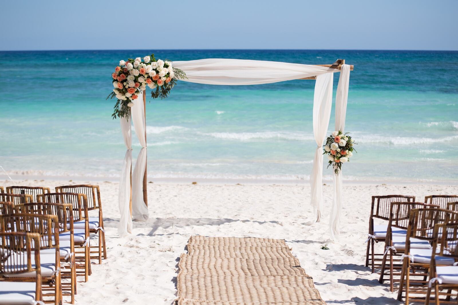 Kyra and Ted's floral ceremony arch beside the Caribbean at Xpu-Ha Beach