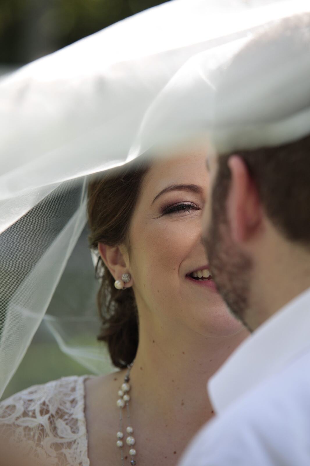Kyra laughing with Ted beneath her veil