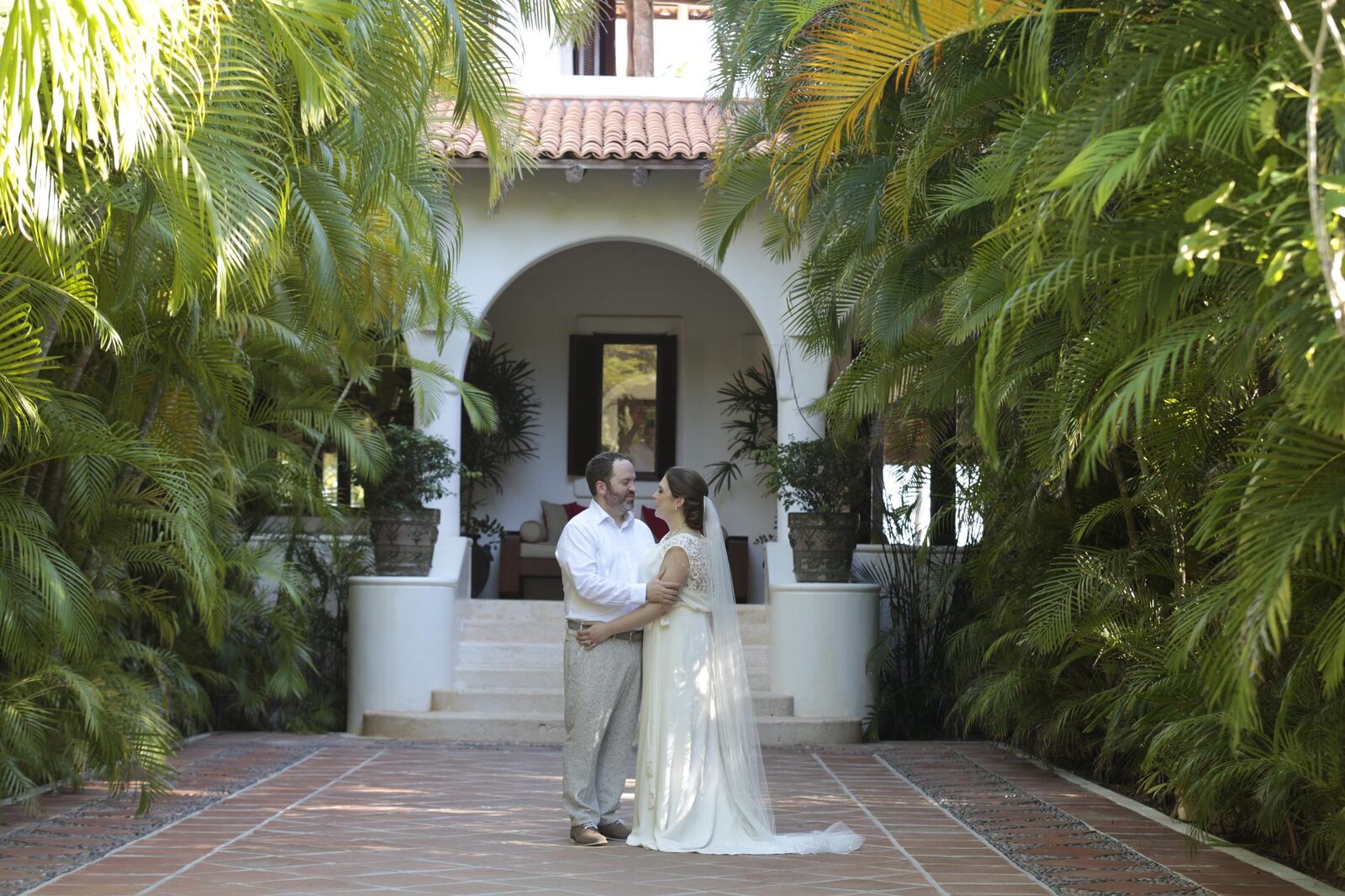 Kyra and Ted framed by the villa and tropical gardens