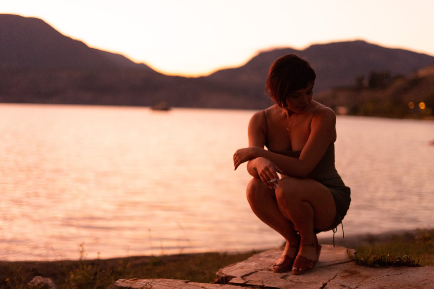 Lucy at the Water’s Edge portraits story frame 2: Lucy at the water’s edge as sunset slips into moonlight, moving from the shoreline and rocks to quiet close portraits and a warm-lit garden after dark. Photographed in Kelowna, BC.