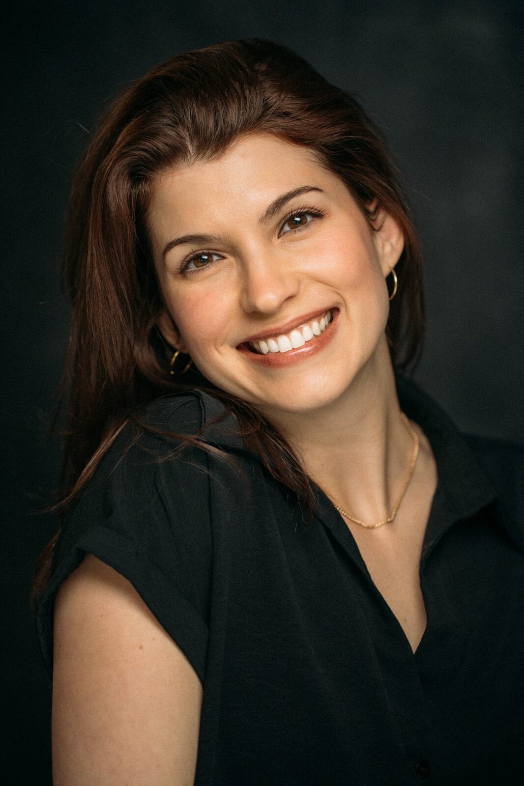 Marie smiling in a black collared shirt