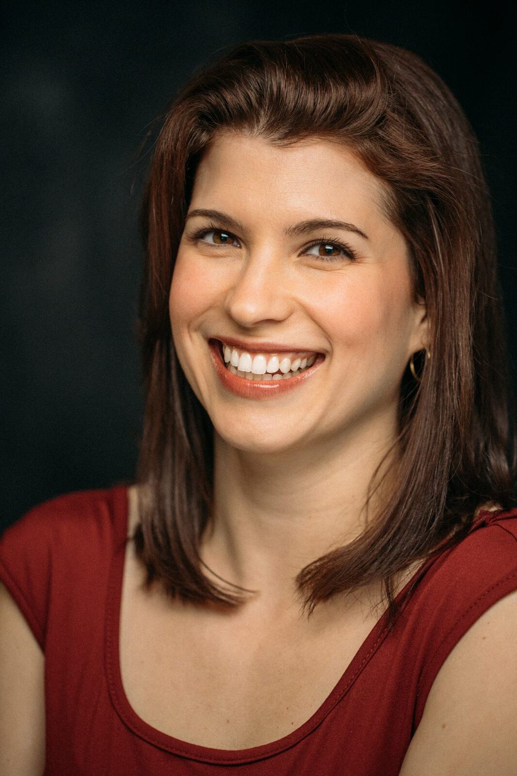 Marie smiling in a red shirt headshot