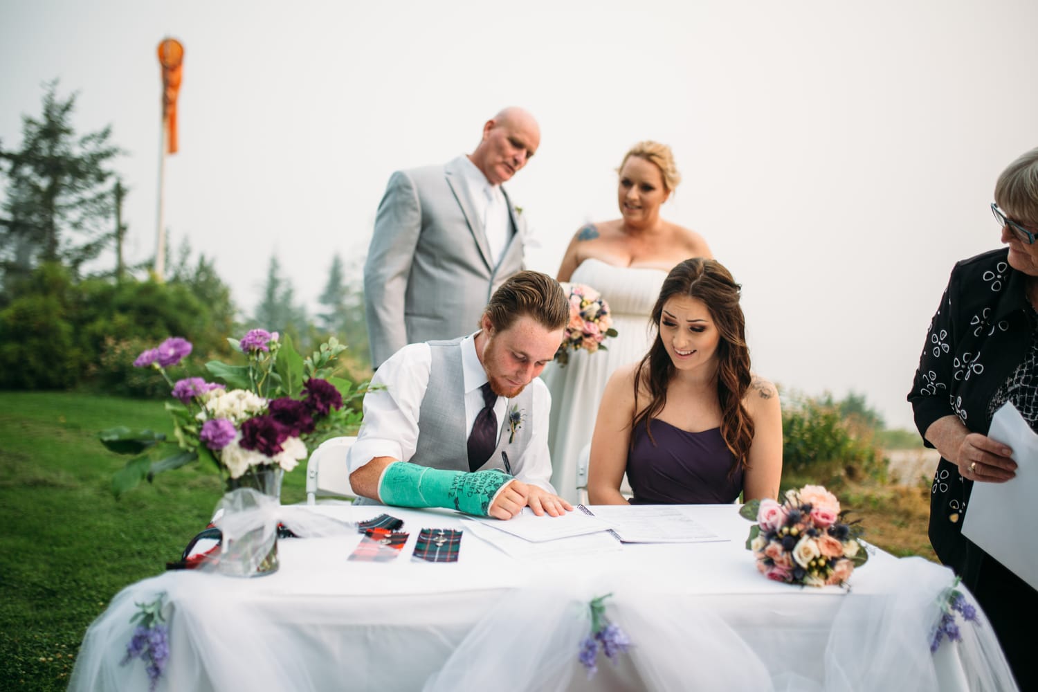 Marie and Mark weddings story frame 19: A Mabel Lake Airpark wedding in the North Okanagan, with grass-runway scenery, open-air photos and sweet family help around makeup, flowers and petals..