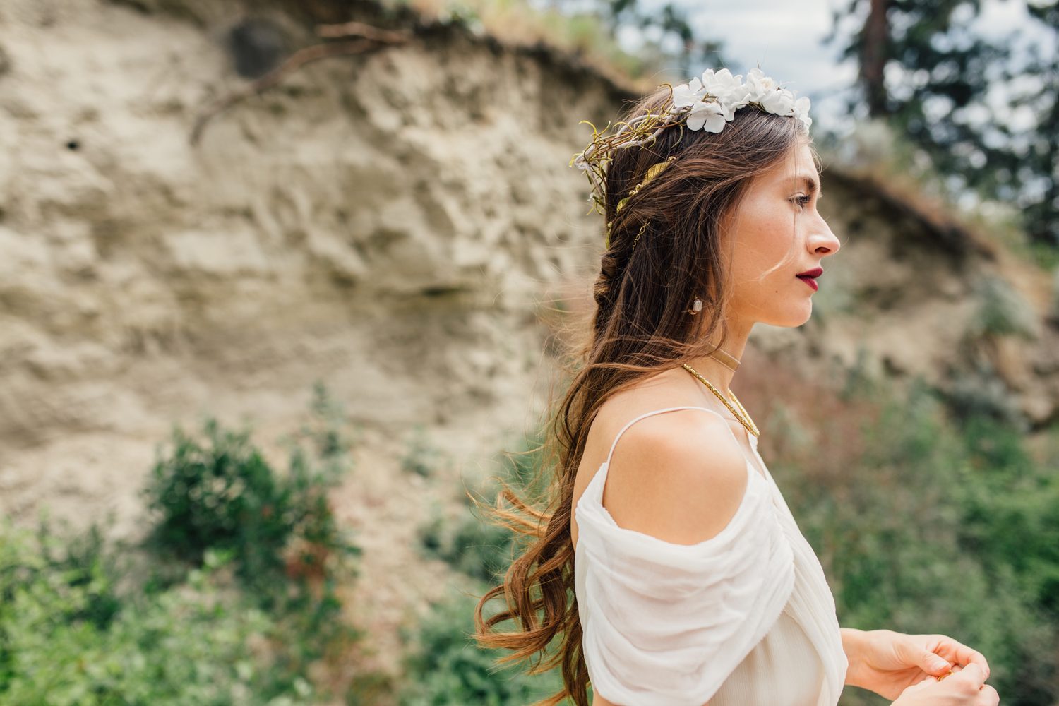 Nicole, White Willow portraits story frame 19: Nicole in a White Willow Photography-designed bridal editorial near Salmon Arm, moving from rock-face portraits through bouquet, veil and flower-crown details.