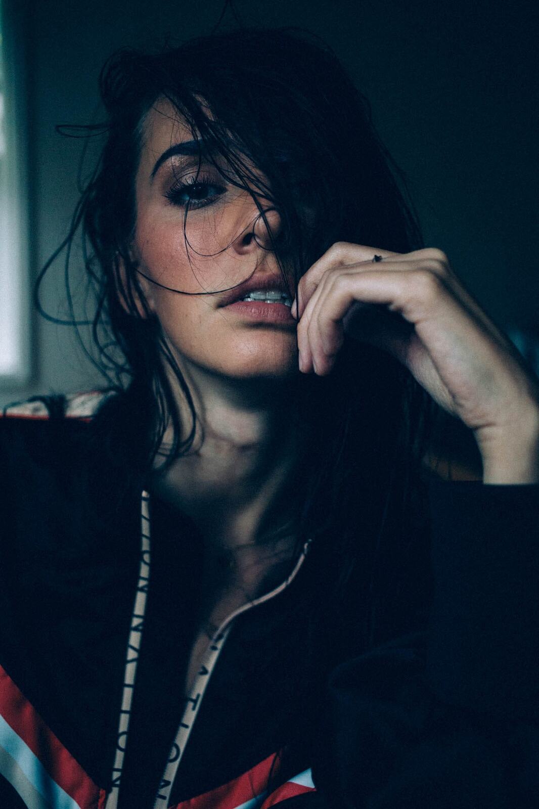 Rebecca in Smoke portraits story frame 2: A dark Kelowna portrait story for Rebecca with window light, smoke, denim, close expression and a low-key editorial mood.