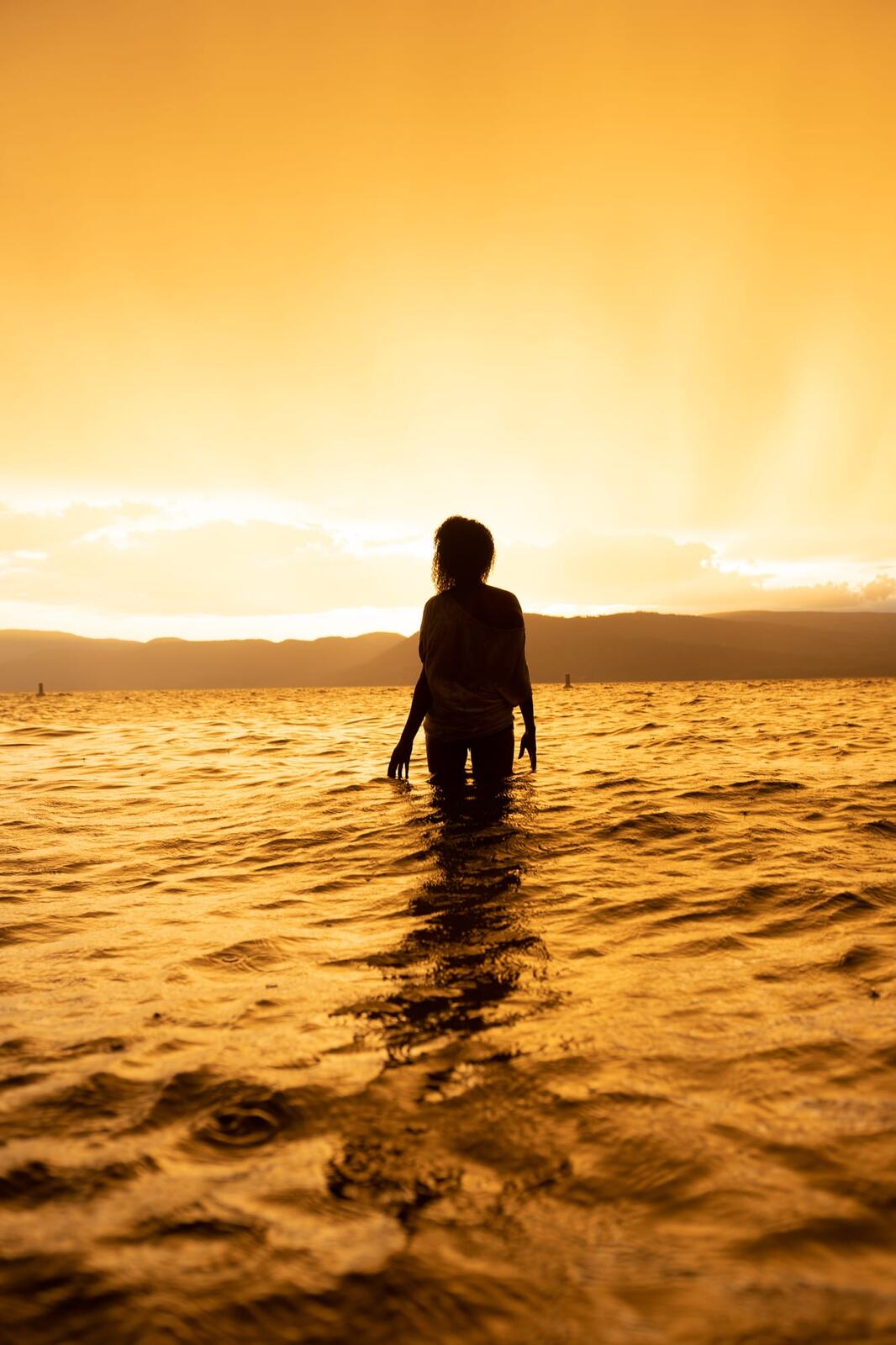Rebekah at Bertram portraits story frame 15: A Bertram portrait story moving from floral dress and lake light into black dress, white shirt, sunset and water silhouettes.