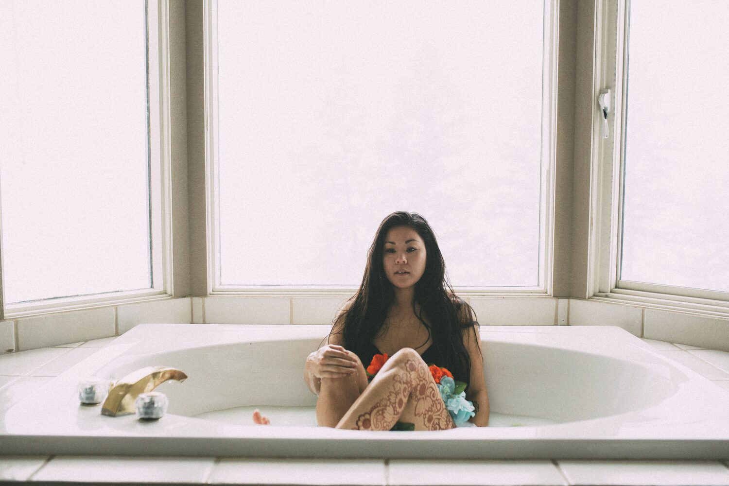 Sarah: Henna, Snow and Candlelight portraits story frame 21: A four-part portrait story with Sarah in Kelowna, moving from a living-room henna session into snow, a daylight coconut-milk bath and a candlelit bath.