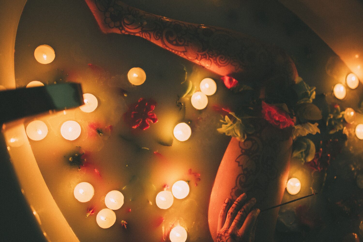 Sarah: Henna, Snow and Candlelight portraits story frame 29: A four-part portrait story with Sarah in Kelowna, moving from a living-room henna session into snow, a daylight coconut-milk bath and a candlelit bath.