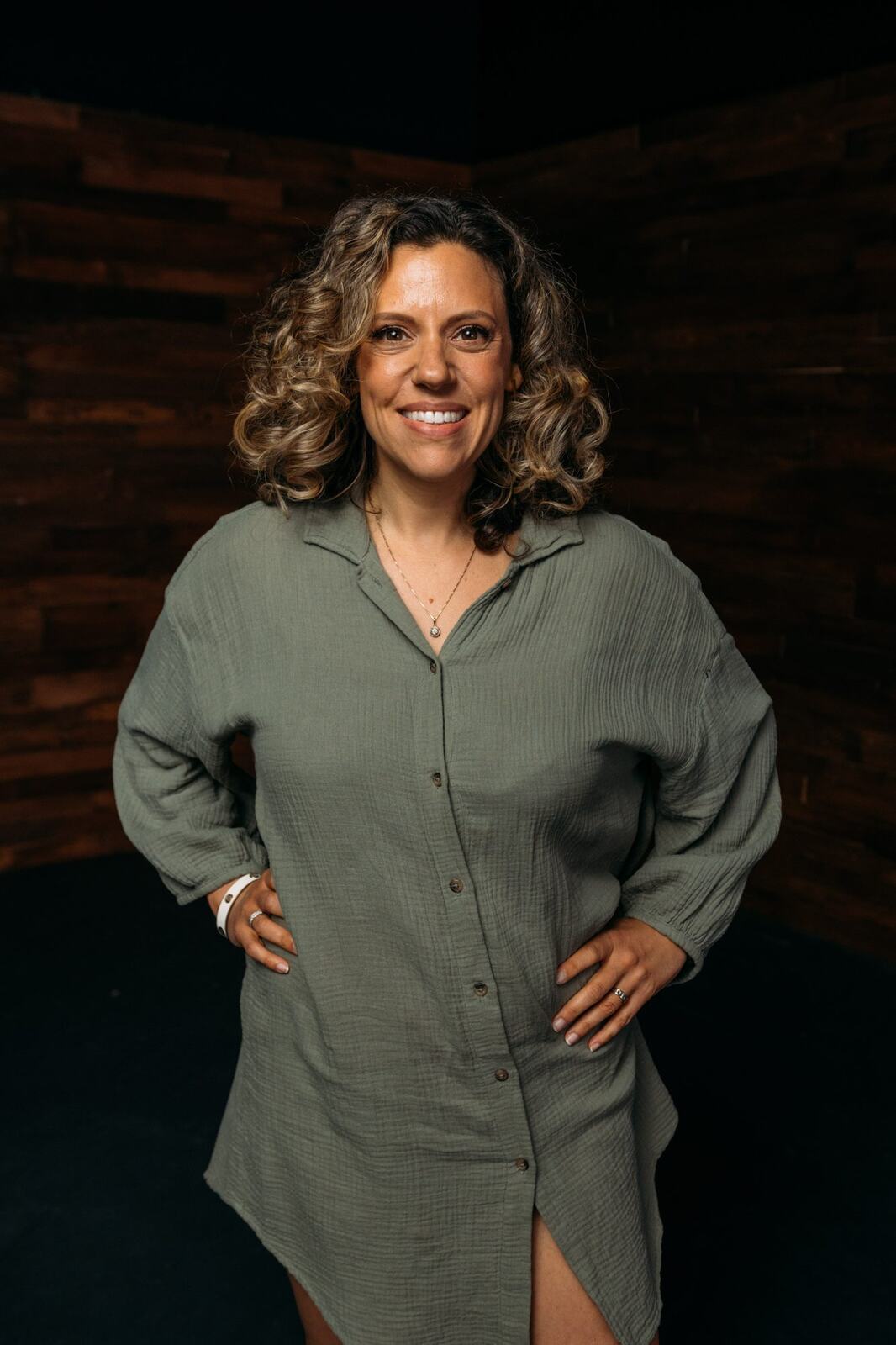 Trisha Miltimore corporate story frame 4: Personal-brand portraits for Trisha Miltimore in Kelowna, moving from clean business profile images into darker wood-wall portraits with black wardrobe and confident brand range..