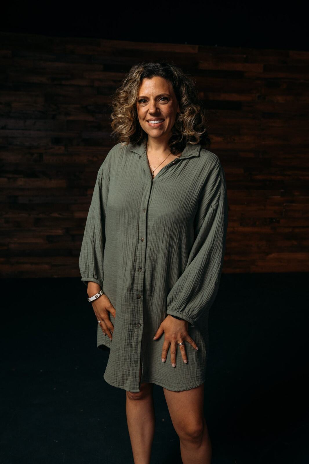 Trisha Miltimore corporate story frame 6: Personal-brand portraits for Trisha Miltimore in Kelowna, moving from clean business profile images into darker wood-wall portraits with black wardrobe and confident brand range..