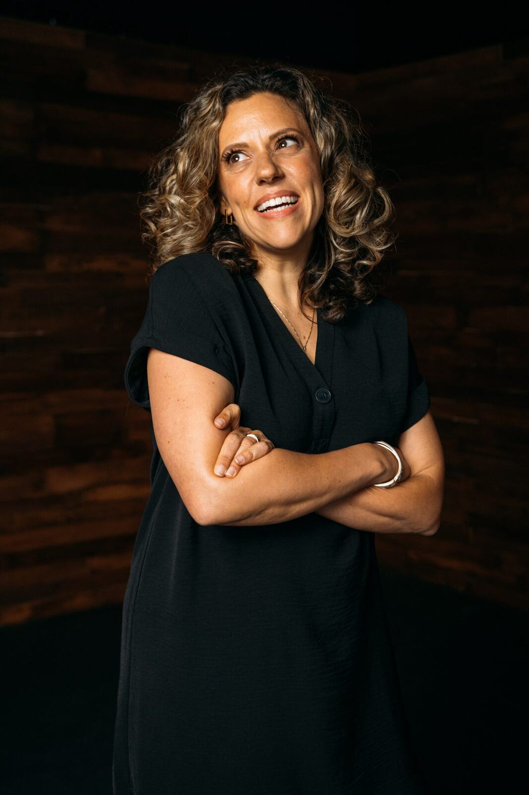 Trisha Miltimore corporate story frame 19: Personal-brand portraits for Trisha Miltimore in Kelowna, moving from clean business profile images into darker wood-wall portraits with black wardrobe and confident brand range..